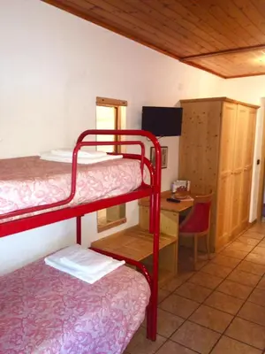 a room with two bunk beds and a desk at Rifugio Sores Adventure in Coredo