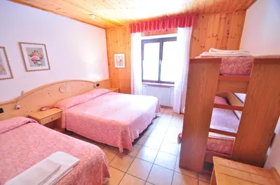 a hotel room with two beds and a window at Rifugio Sores Adventure in Coredo