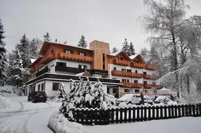 a building covered in snow with a fence in front of it at Rifugio Sores Adventure in Coredo