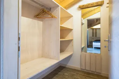 a room with a closet with wooden shelves at Rifugio Sores Adventure in Coredo