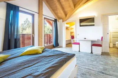 a bedroom with a bed and a large window at Rifugio Sores Adventure in Coredo
