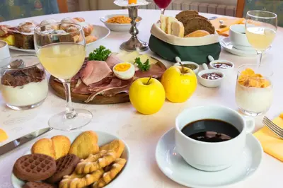 a table with a breakfast of food and drinks at Rifugio Sores Adventure in Coredo