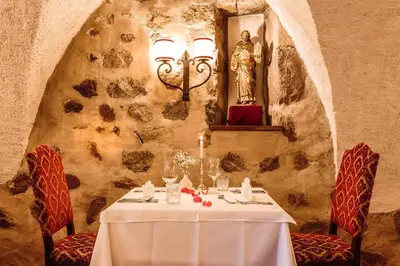 a table in a restaurant with a statue of a woman at Hotel Castel Rundegg (Adults Only) in Merano