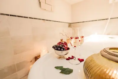 a table with two glasses of wine and a bowl of fruit at Hotel Castel Rundegg (Adults Only) in Merano