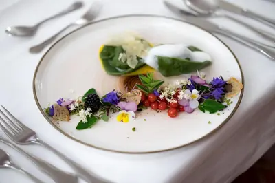 a white plate with some food on a table at Hotel Castel Rundegg (Adults Only) in Merano
