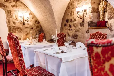 a dining room with white tables and red chairs at Hotel Castel Rundegg (Adults Only) in Merano