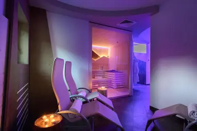 a purple room with a pair of shoes in front of a mirror at Hotel Garni Roberta in Malga Ciapela