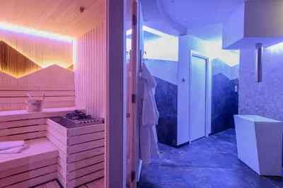 a bedroom with a bed and a table and a window at Hotel Garni Roberta in Malga Ciapela