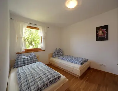 a bedroom with two beds and a window at Rumpelehof in Villandro