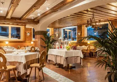 a restaurant with white tables and chairs in a room at Parc Hotel Victoria in Cortina dʼAmpezzo