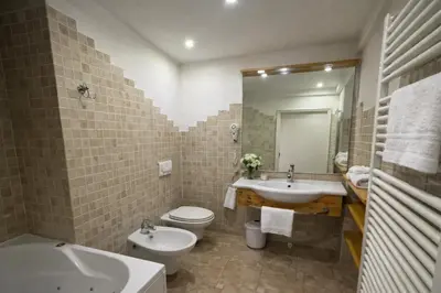 a bathroom with a sink and a toilet and a tub at Parc Hotel Victoria in Cortina dʼAmpezzo