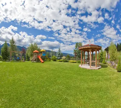 a park with a gazebo and a playground at Hotel Lagorai Resort & Spa in Cavalese