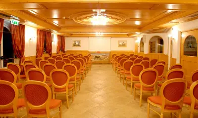 a room with rows of chairs in a building at Hotel Lagorai Resort & Spa in Cavalese