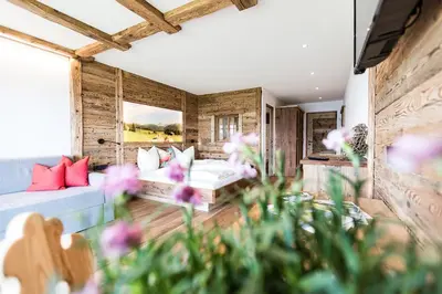a room with two beds and flowers in the foreground at Ahner Berghof in Rodengo