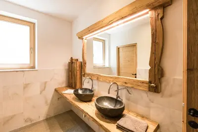a bathroom with two sinks and a mirror at Ahner Berghof in Rodengo
