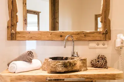 a bathroom with a stone sink and a mirror at Ahner Berghof in Rodengo