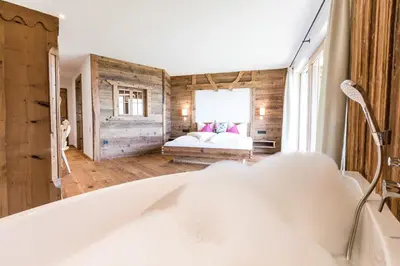 a bathroom with a tub and a bed in a room at Ahner Berghof in Rodengo