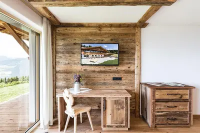 a wooden room with a table and a tv on a wall at Ahner Berghof in Rodengo