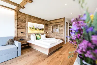 a bedroom with a bed and a couch and flowers at Ahner Berghof in Rodengo