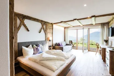 a bedroom with a bed in a room with windows at Ahner Berghof in Rodengo