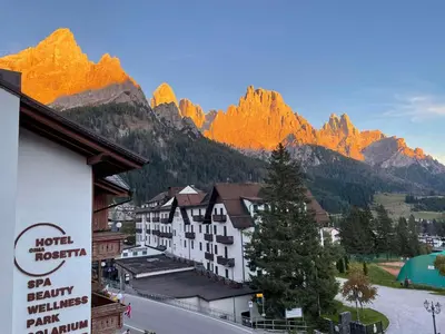 a bedroom with a bed and a tv in a room at Hotel Cima Rosetta - BW Signature Collection in San Martino di Castrozza