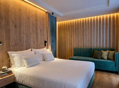 a bedroom with a bed and a flat screen tv at Hotel Cima Rosetta - BW Signature Collection in San Martino di Castrozza