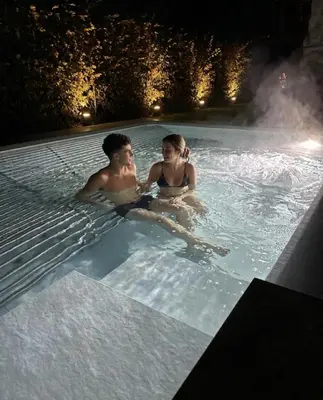 a man and woman sitting in a sauna at Hotel Cima Rosetta - BW Signature Collection in San Martino di Castrozza