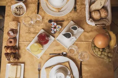 a table with plates of food on it with eggs and bread at Hotel Dolomiti Schloss in Canazei