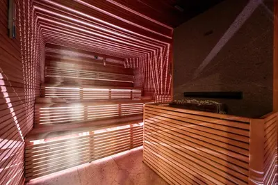 a room with wooden walls and a window with blinds at Hotel il Caminetto Sport in Canazei
