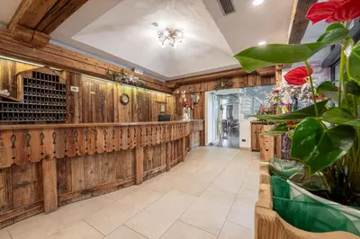 a large hallway with wood paneling and a bar at Hotel il Caminetto Sport in Canazei