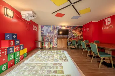 a room with a table and chairs and a tv at Hotel il Caminetto Sport in Canazei