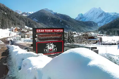 a sign for a ski resort in the snow at Hotel il Caminetto Sport in Canazei