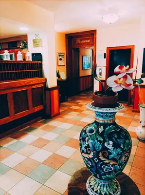 a vase with a flower in the middle of a room at IHR Hotel Villa Emma in Canazei