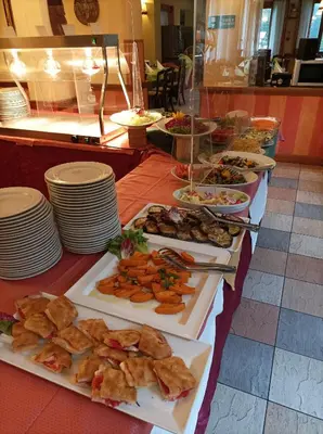 a buffet of food on a table with plates of food at IHR Hotel Villa Emma in Canazei