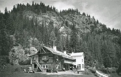 a black and white photo of a house in front of a mountain at Hotel Villetta Maria Cottage in Canazei