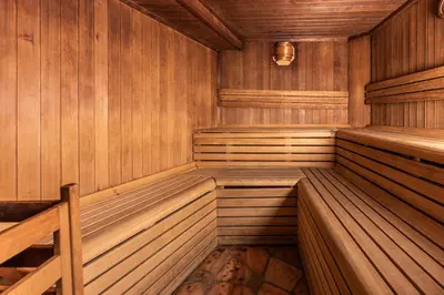an empty wooden sauna with wooden floors and walls at Hotel Soreghes Gran Chalet in Campitello di Fassa
