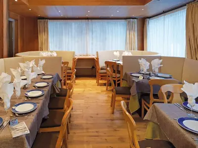 a dining room with tables and chairs and a window at Hotel Diamant Park in Campitello di Fassa