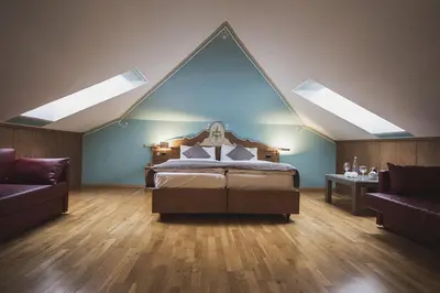 a bedroom with a bed and a desk and a television at Hotel Rubino Deluxe in Campitello di Fassa