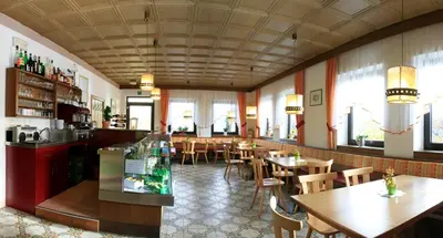 a restaurant with wooden tables and chairs and windows at Pension Rastnerhof in Luson