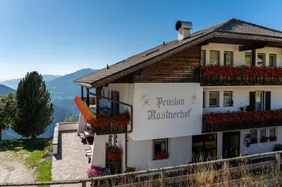 a building with flowers on the side of it at Pension Rastnerhof in Luson