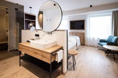 a bathroom with a sink and a mirror at Hotel Baumwirt in Castelrotto