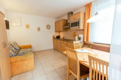 a kitchen with a table and chairs in a room at Haus Angelika in Nova Levante