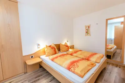 a bedroom with a large bed and a mirror at Haus Angelika in Nova Levante