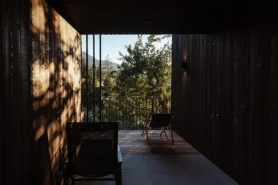 a room with a balcony with a chair and a window at naturApart in Brunico