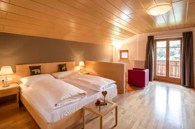 a bedroom with a large white bed in a room at Am Rainell Hof in Ortisei