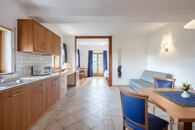 a kitchen and living room with a table and chairs at Am Rainell Hof in Ortisei