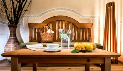 a wooden table with a vase and fruit on it at Mirabell Alpine Garden Resort & Spa in Siusi
