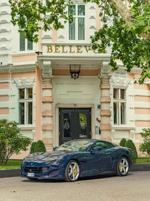 a blue car parked in front of a building at Grand Hotel Bellevue - adults only in Merano