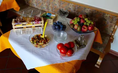 a table with bowls of fruit on a table at Gruberhof in Postal
