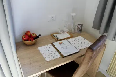 a table with a book and a basket of apples on it at Gruberhof in Postal